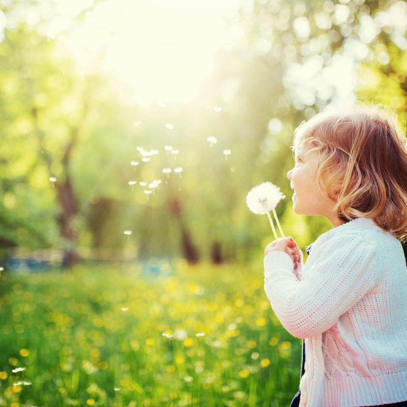 child playing outdoors in the grass in the park